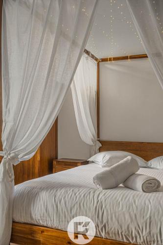 a bedroom with a white bed with a canopy at R'Apparts Studio Cocooning Végétal in Grenoble