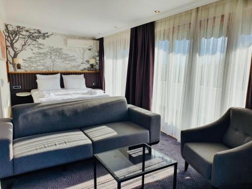 a living room with a couch and a bed at DOUBLE ROYAL HOTEL in Kocaeli
