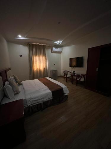 a large hotel room with a bed and a desk at Fakher Yanbu Hotel in Yanbu