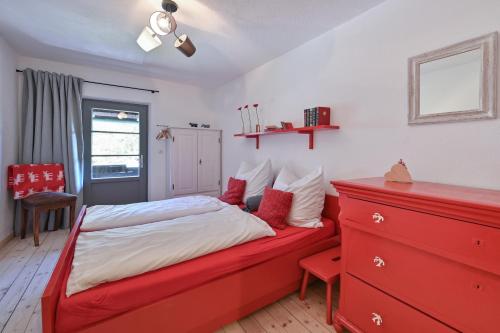 a bedroom with a red bed and a red dresser at Exklusives und Modernes Bauernhaus in Nesselwang