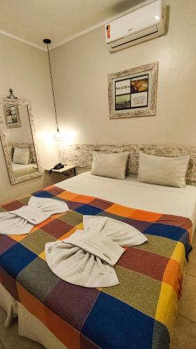 a bedroom with a bed with towels on it at Pousada Vila Parnaíba in Parnaíba