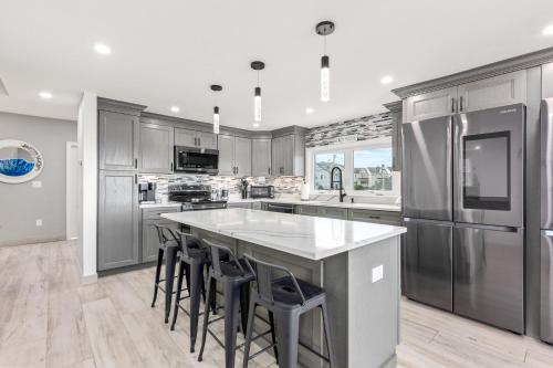 a kitchen with a large island with bar stools at Oceanside Luxury Home Hampton Beach in Hampton