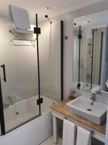 a bathroom with a sink and a tub and a mirror at DOUBLE ROYAL HOTEL in Kocaeli