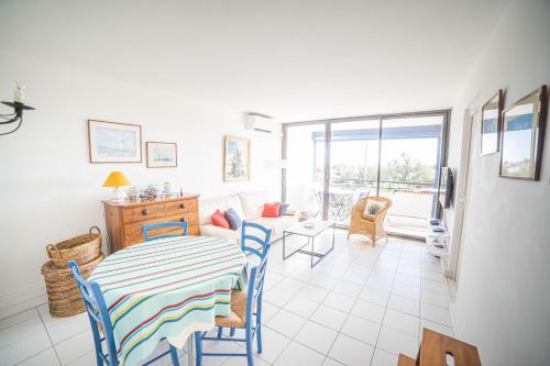 une salle à manger avec une table et des chaises et un salon dans l'établissement LE SUNRISE Vue mer Accès Plage- Spacieux-2 Terrasses-Wifi - CONFORT -TOP PROS SERVICESConciergerieLaGrandeMotte, à La Grande Motte
