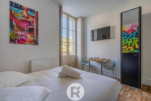 a bedroom with a bed and a table with chairs at R'Apparts Studio Street Art in Grenoble