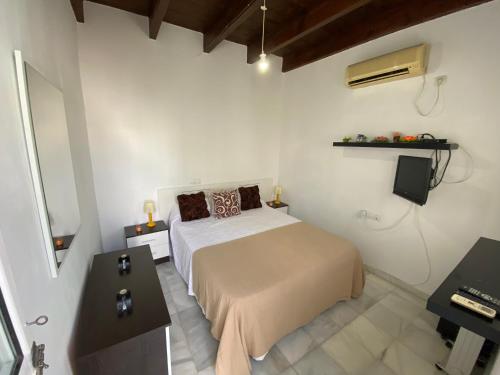 a white bedroom with a bed and a desk at Sweet Triana in Seville