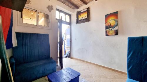 a living room with a blue couch and a window at Good Vibes House Imsouane in Imsouane