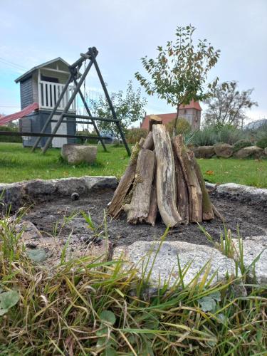 a pile of logs in front of a playground at Domek na wsi- Przezmark pod Elblagiem in Elblag