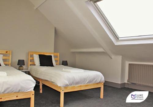 a attic bedroom with two beds and a skylight at Luke Stays - Brighton Road in Gateshead