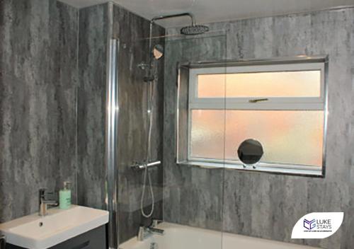 a bathroom with a shower and a sink and a window at Luke Stays - Brighton Road in Gateshead