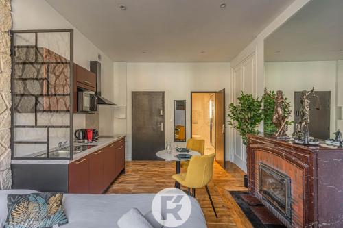 Il dispose d'une cuisine et d'un salon avec un canapé et une cheminée. dans l'établissement R'Apparts Studio Chic des Quais, à Grenoble