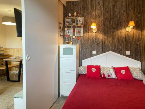ein Schlafzimmer mit einem roten Bett mit roten Kissen in der Unterkunft Confortable 2 pièces aux pieds des pistes, quartier Falaise, Avoriaz - FR-1-634-66 in La Côte dʼArbroz