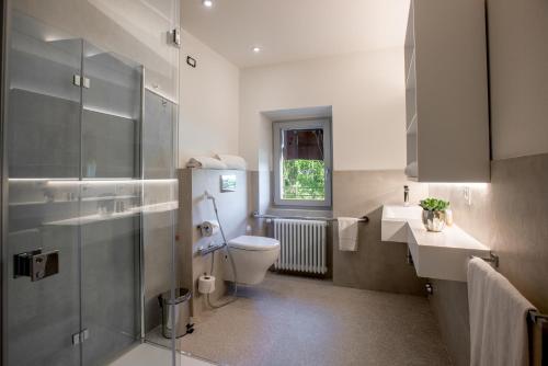 a bathroom with a toilet and a sink and a window at La Locanda di Petriolo in Monticiano