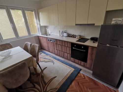 a kitchen with wooden cabinets and a table and a refrigerator at 007 Apartments - Strumica, Macedonia in Strumica