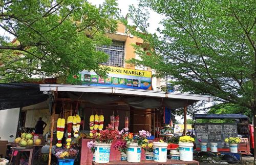a fruit market with flowers in front of a building at Bdr Bukit Tinggi Klang Tropicana Garden Homestay in Klang