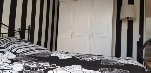 Schlafzimmer mit einem Bett mit einer schwarzen und weißen Bettdecke in der Unterkunft Drosselnest Moderne Design-Wohnung Hier ist alle neu! in Minden