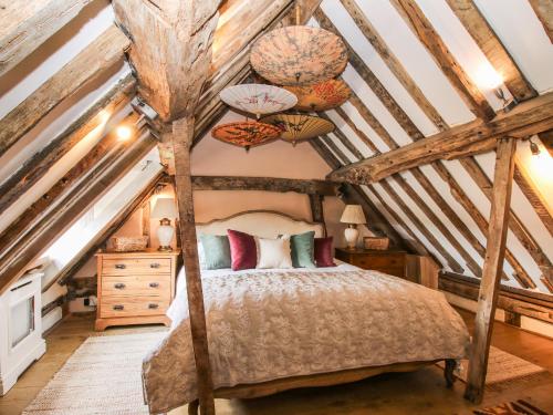 a bedroom with a bed in the attic at Cobblers Cottage in Whitchurch