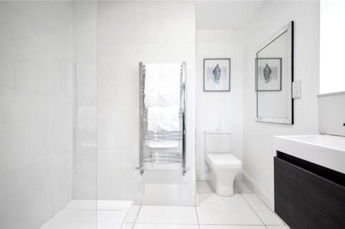 a white bathroom with a shower and a toilet at Hampshire gated home in exclusive location in Southampton