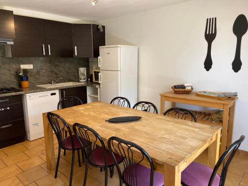 - une cuisine avec une table en bois et des chaises dans l'établissement Village de gites Mas de la Bastide, à Joyeuse