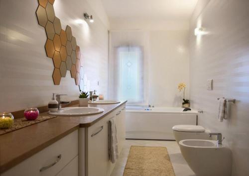 ein Badezimmer mit zwei Waschbecken, einem WC und einer Badewanne in der Unterkunft Villa Taranta in Racale