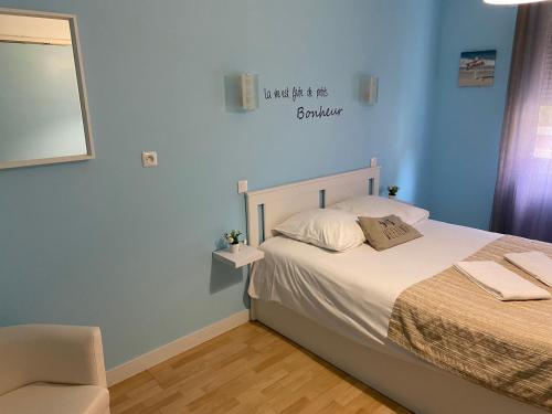 een kleine slaapkamer met een bed en een stoel bij LA DAME DE COEUR in Soulac-sur-Mer
