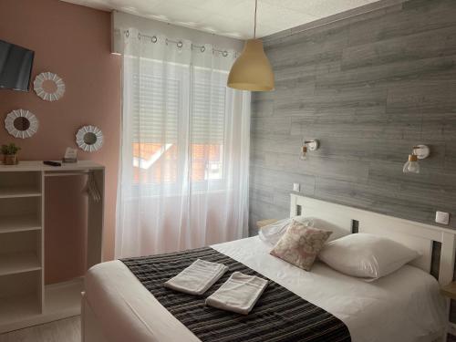 - une chambre avec un lit et 2 serviettes dans l'établissement LA DAME DE COEUR, à Soulac-sur-Mer