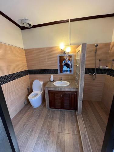 a bathroom with a toilet and a sink and a mirror at Lewiinski's Hotel in Pattaya Central