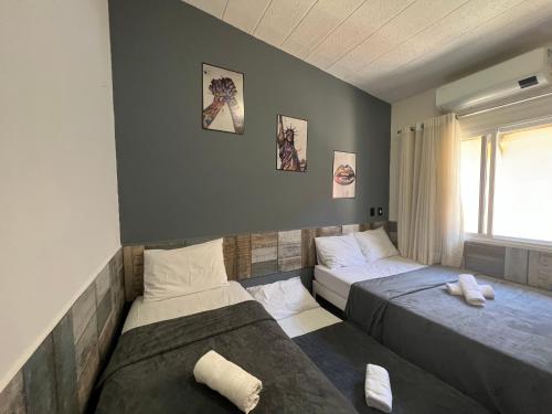 een slaapkamer met 2 bedden en een raam bij Paraíso PÉ NA AREIA no coração do Litoral Norte - FRENTE MAR - Loft projetado para que você tenha a melhor experiência em hospedagem - condomínio mais procurado da Estrada do Côco - Varanda com vista espetacular para o mar - lazer e TRANQUILIDADE in Camaçari