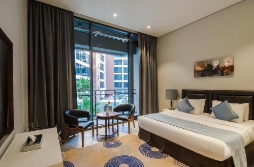 a hotel room with a bed and a balcony at Boudl Al Jubail in Al Jubail