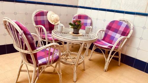 une table avec des chaises roses et une table avec des fleurs. dans l'établissement Amazing sweet house sea view Costa Blanca, swimming pool, 4 bedrooms, à Santa Pola