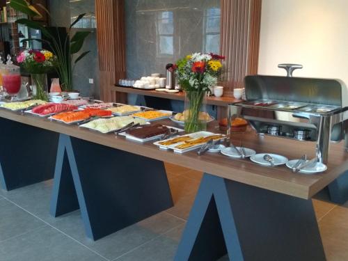 um buffet com muitos tipos diferentes de comida em uma mesa em Hotel Global Grupos em São Paulo