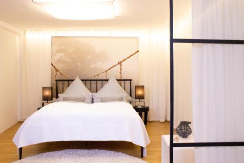 a bedroom with a white bed with white sheets at Como Design-Apartment close to Isar river area - centrally located in Munich