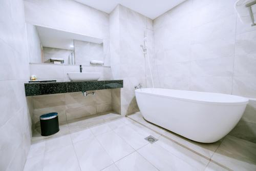 The Concept Hotel Langkawi في كواه: حمام أبيض مع حوض ومغسلة