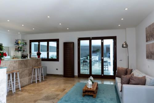 a living room with a couch and a kitchen with windows at The Florence Hills Resort & Wellness in Pelago