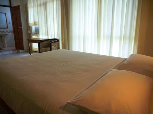 a large bed in a bedroom with a window at Grand Hotel Mercedes in Pucallpa