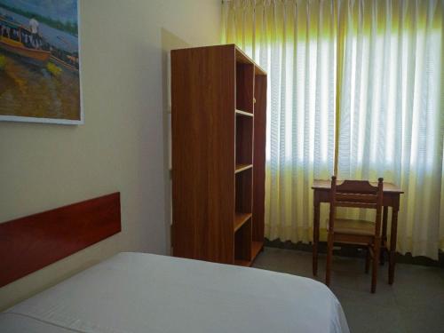 a bedroom with a bed and a cabinet and a table at Grand Hotel Mercedes in Pucallpa