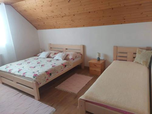 a bedroom with two beds and a wooden ceiling at PENZIÓN U JANOSIKA in Terchová