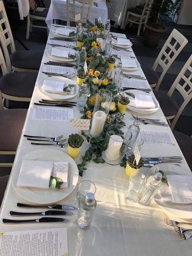 a long table with white plates and utensils on it at All Seasons Residence Design Hotel - Free parking in Sofia