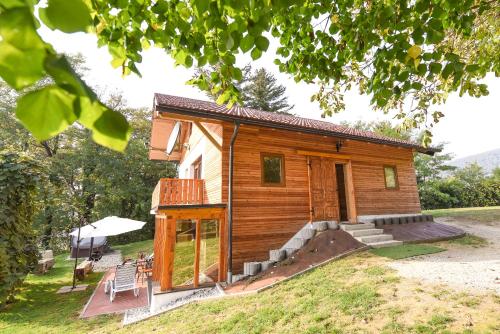 a small wooden cabin with a porch and a patio at Holiday Home Liberg with Hot tub and Sauna in Brežice