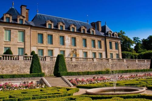 un gran edificio con una fuente frente a él en Appartement cosy au coeur d'Auvers-Sur-Oise, en Auvers-sur-Oise