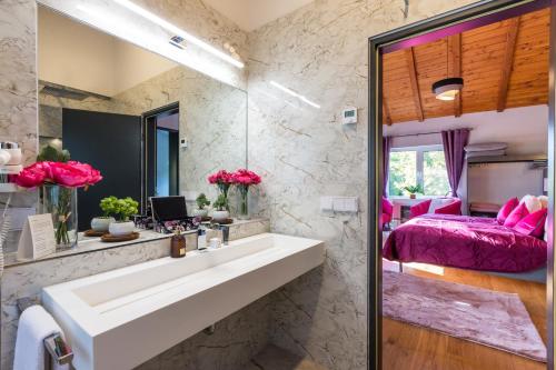 a bathroom with a sink and a bedroom at Villa Tropicana Berlin Potsdam in Teltow