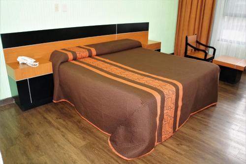 Cama grande en habitación con suelo de madera en Hotel Castro, en Ciudad de México