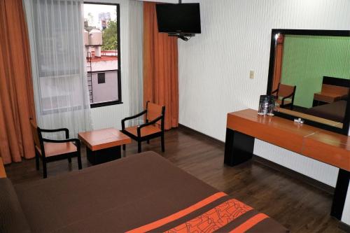 Habitación con cama, escritorio y espejo. en Hotel Castro en Ciudad de México