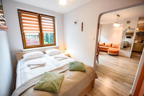 1 dormitorio con cama y ventana grande en Apartamenty Sun & Snow Kraszewskiego, en Krynica-Zdrój