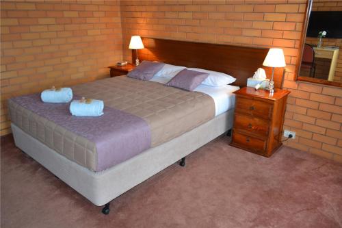 a bedroom with a large bed and two night stands at Grong Grong Motor Inn in Grong Grong