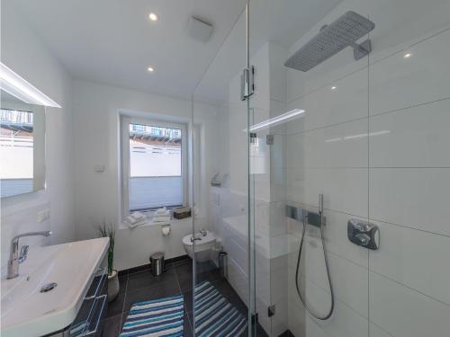 a white bathroom with a shower and a sink at Ferienwohnungen in der alten Tuchfabrik Malchow in Malchow