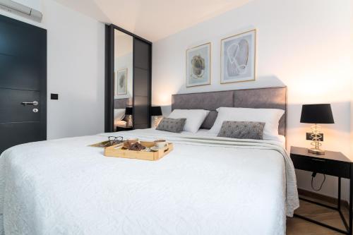 1 dormitorio con 1 cama blanca grande y bandeja de madera. en Luxury apartment Love Nest - near the center and the beach, en Krk