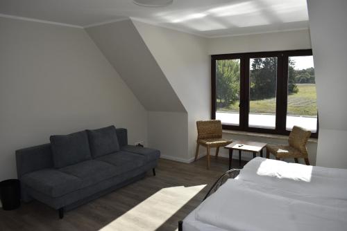 uma sala de estar com um sofá e uma cama em Pension zur Schleuse am Elbe Lübeck - Kanal in Witzeeze em Witzeeze