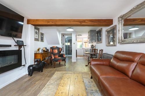 a living room with a couch and a tv at Georgina in Lavenham