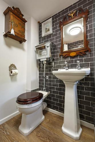 a bathroom with a toilet and a sink at Georgina in Lavenham